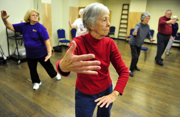 Betty Cook, of Central, center, follows her instructor, Yajun ‘Thomas’ Zhuang, during a tai chi class at LSU. The class, part of LSU’s kinesiology program, helps people with peripheral neuropathy, which affects their balance and mobility. Spouses and friends without the condition also  participate, providing comparison for research.